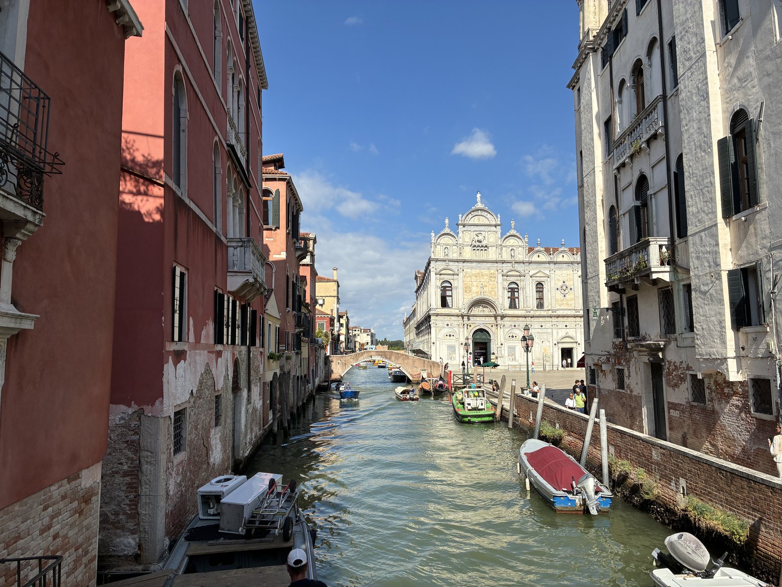 Blick entlang eines Kanals in Venedig mit Booten und einer weißen Marmorfassade am Ende